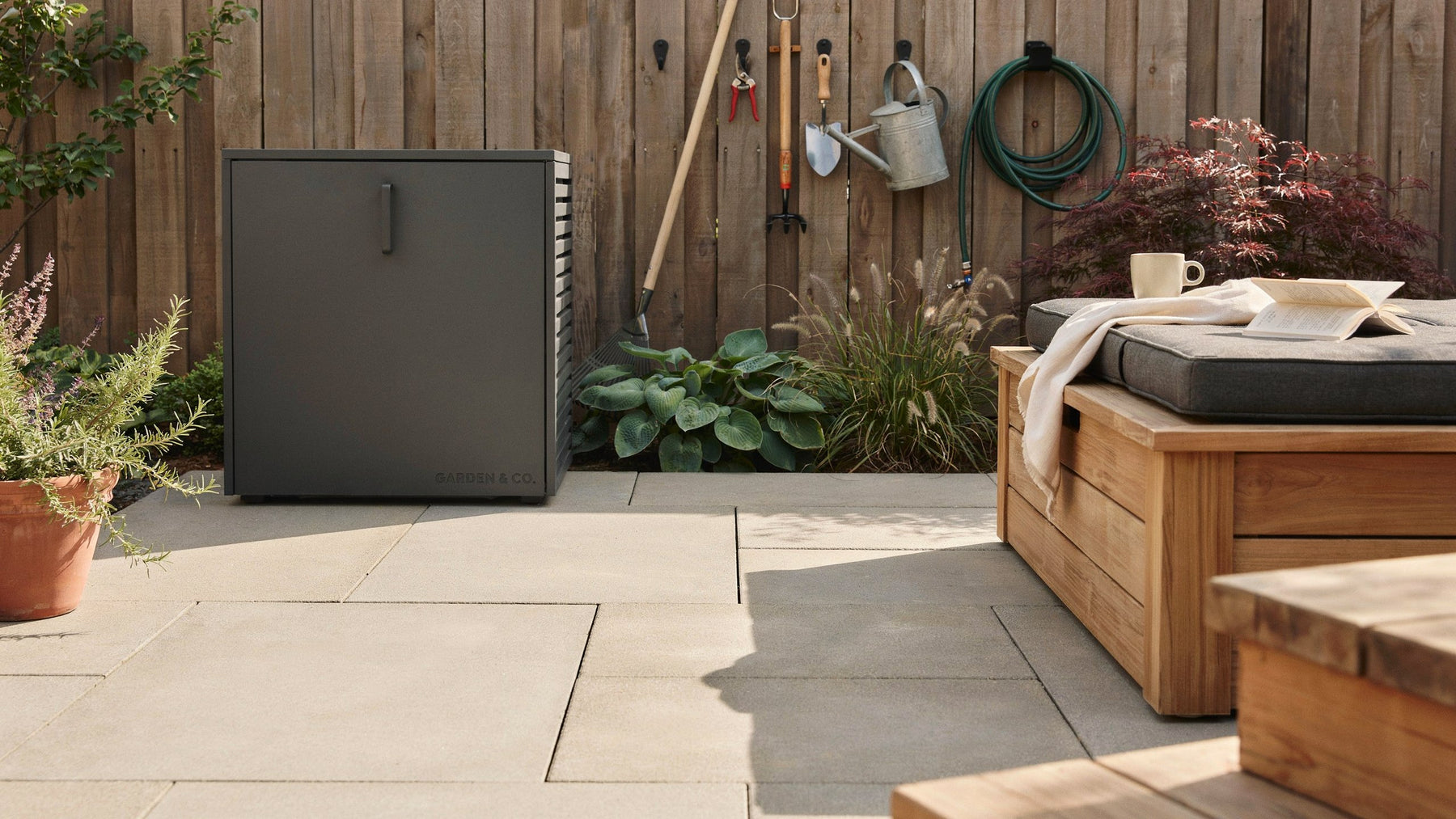 Neatly organized backyard with modern outdoor storage cabinet and garden tools